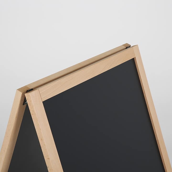 Close up of the top corner of a wooden blackboard A-frame, showing the timber frame and black panel