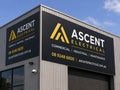 Large aluminium composite panel sign for an electrical contractor mounted on the corrugated wall of an industrial unit