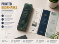 Printed bookmarks in green, navy and cream fanned across a desk beside a stack of matching bookmarks