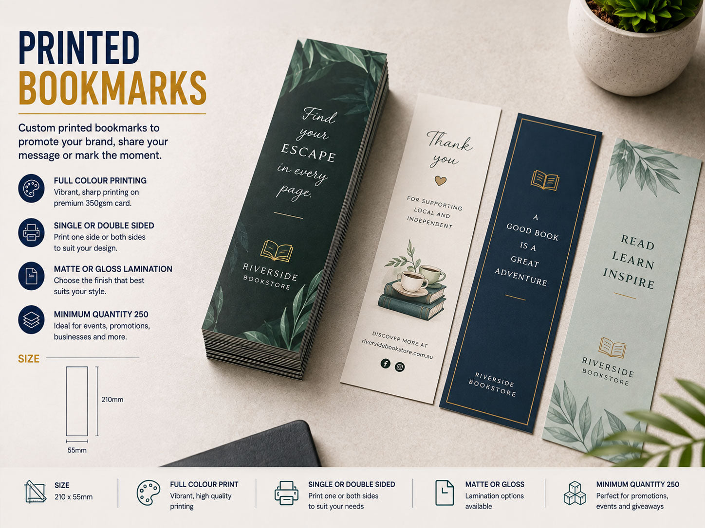 Printed bookmarks in green, navy and cream fanned across a desk beside a stack of matching bookmarks