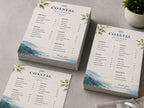 Printed restaurant menus in two sizes stacked on a table beside cutlery and a napkin