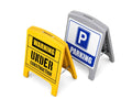 Two moulded plastic A-frame signs, one yellow reading Warning Under Construction and one grey showing a blue parking symbol