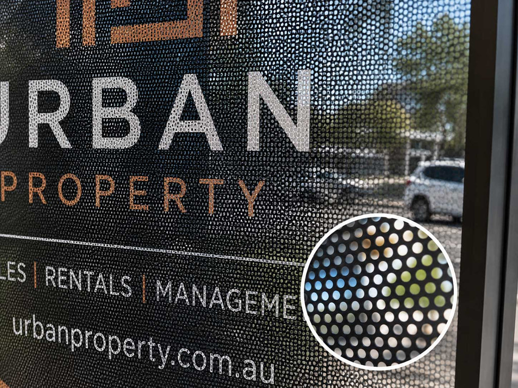 One way vision film on a real estate office window, with a close up showing the perforated dot pattern