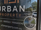 One way vision film on a real estate office window, with a close up showing the perforated dot pattern
