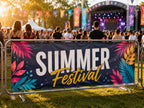 Printed PVC banner cable tied to crowd barriers at an outdoor summer music festival