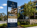 Freestanding pylon sign for an apartment development, printed in vinyl and installed in a landscaped garden