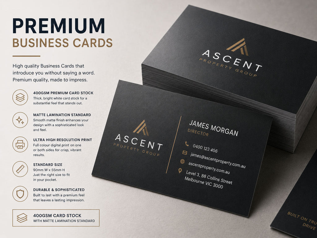 Premium black business cards with gold foil detailing, stacked and fanned on a pale surface