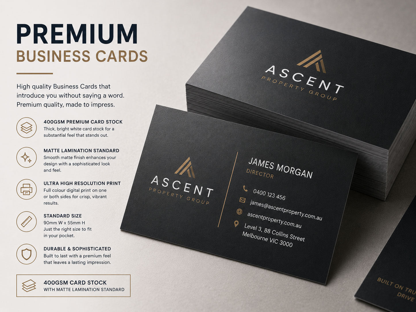 Premium black business cards with gold foil detailing, stacked and fanned on a pale surface