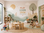 Childcare playroom with a removable vinyl wall mural showing hills, a tree and the words Play Learn Grow