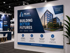 Large printed screenboard sign forming the back wall of a construction company exhibition stand