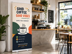 Pull up banner stand beside the counter in a cafe, printed with Good Coffee Good Vibes artwork