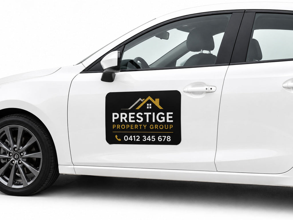 Black magnetic vehicle sign for a property group applied to the door of a white car