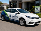 Partial vehicle wrap on a white real estate sedan parked outside a home with a matching for sale sign