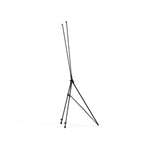 Side view of a black X frame tripod stand folded partly closed, showing the legs and arms