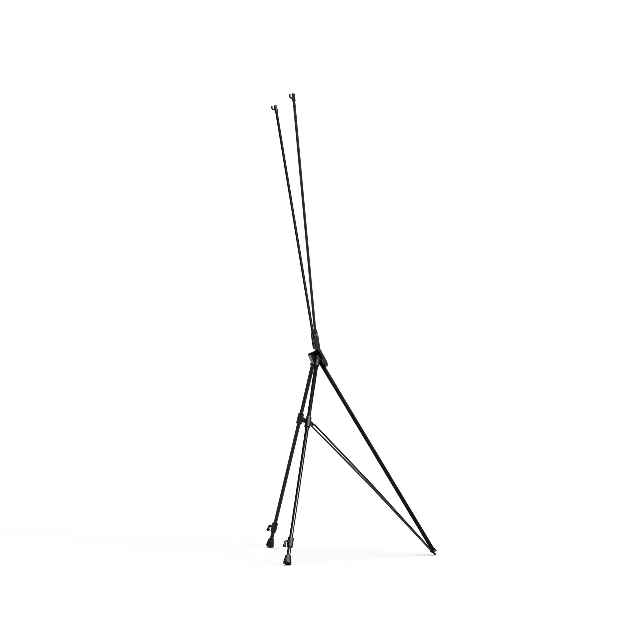Side view of a black X frame tripod stand folded partly closed, showing the legs and arms